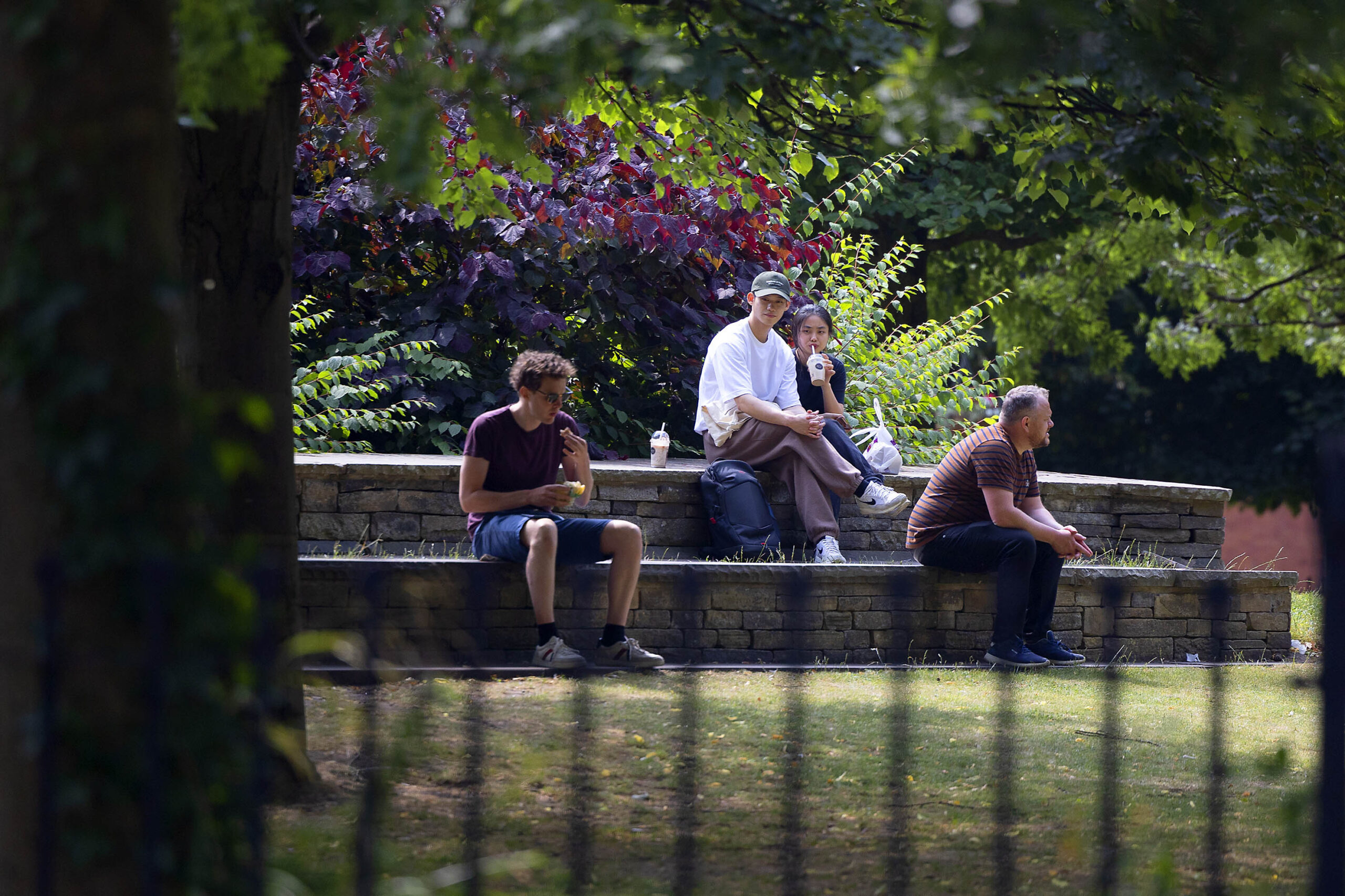 People enjoying the sun in All Saints Park Manchester Oxford Road Corridor