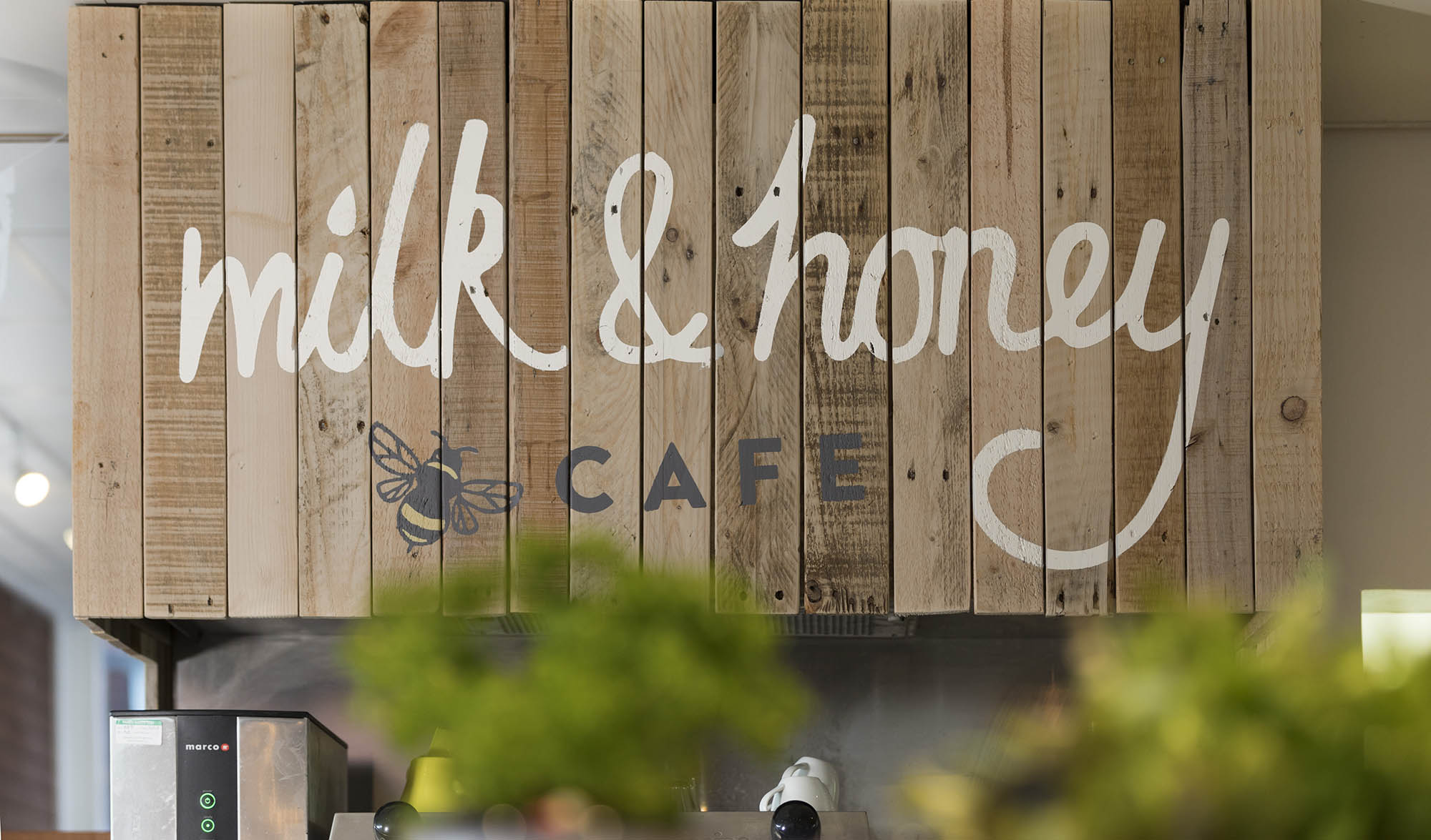 A picture of signage at Milk & Honey Cafe, printed on wood panels