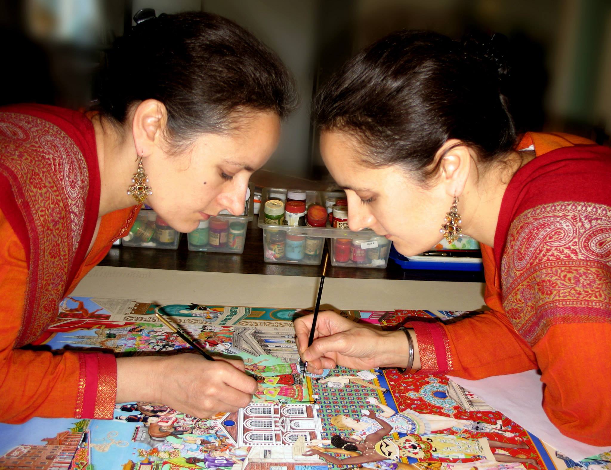 The Singh Twins both working on a painting