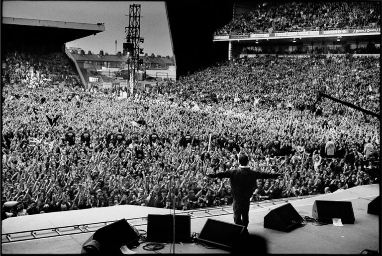 Noel Gallagher performing with Oasis at Maine Road in 1996 by Jill Furmanovsky